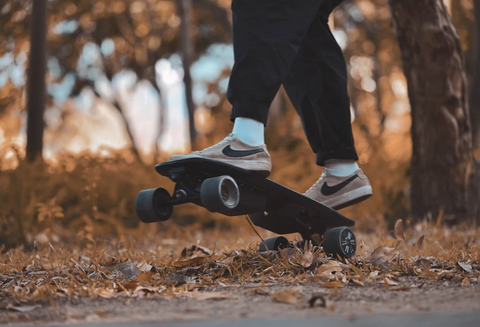 Meepo mini board in autumn leaves with feet riding it- board is elevated off the ground