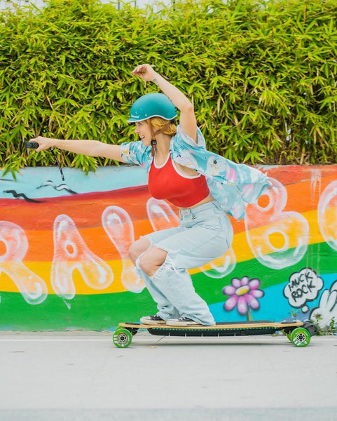 Female wearing Thousand Helmet Riding an Evolve Skateboard