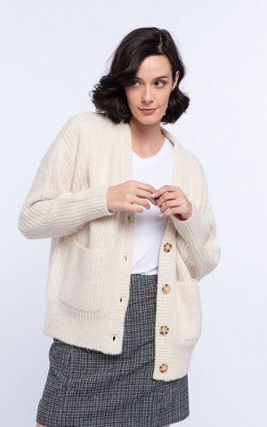 Nothing Says Winter like a Versatile, Chunky Knitted Cardigan. The Bailey is a Neutral Cream Colour that goes with Everything and is a Winter Wardrobe Staple. It has Light Brown Tortoiseshell Button Closures at the Front and can be worn Open or Closed over your Outfit. It has Large Pocket Details and is Soft to the touch, Warm & Cosy for the Festive Season.