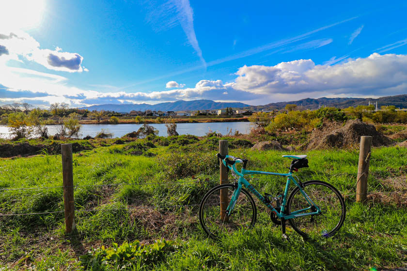 Un vélo de route avec la rivière Katsura en arrière-plan.