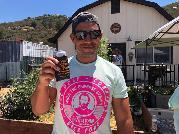 Man in the sun holding can with koozie