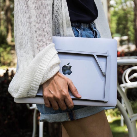 woman holding a macbook pro and rain design mbar pro+ folded flat