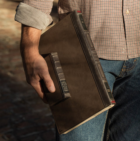 man holding a twelve south bookbook macbook case and bookbook iphone case.