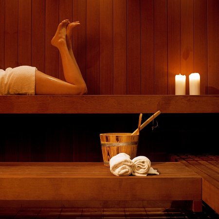 woman in a wood  dry sauna with accesories