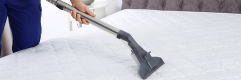 closeup of a vacuum being used on a mattress