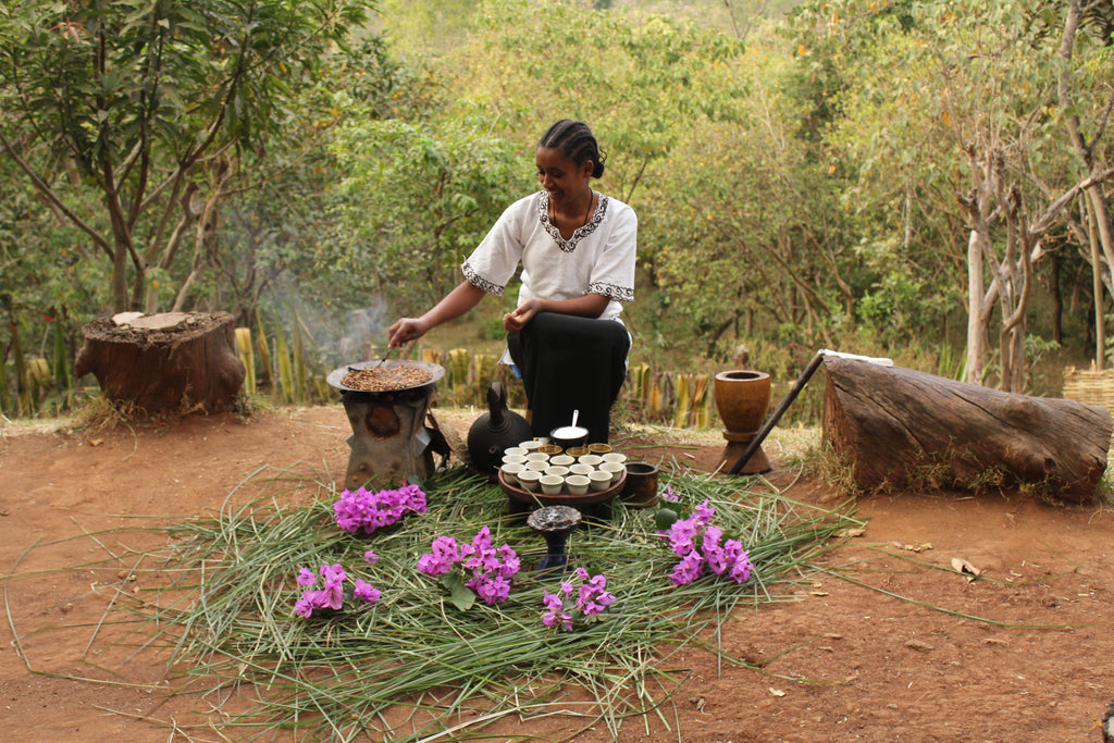 Ethiopian woman, roasting and brewing coffee outside