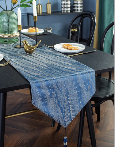 photo of a dining table with blue table runner and design accessories