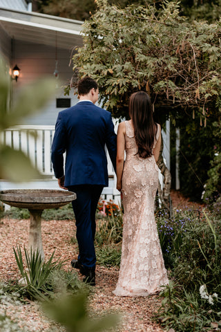 newlywed couple walking, facing away