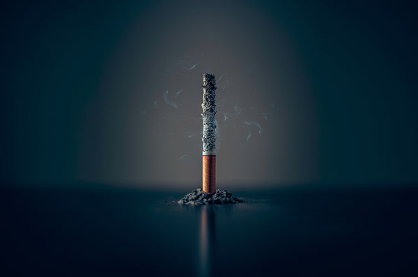 Una sigaretta in piedi con la cenere che la consuma