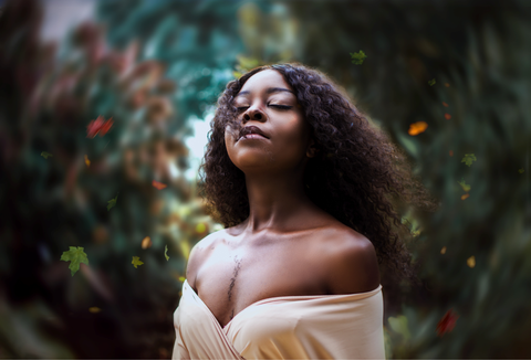 woman standing with her eyes clothes and hair blowing in the wind