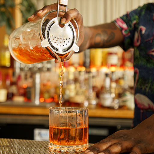 Bartender Pours Red Liquid From Jigger Into Mixing Cup Stock Photo