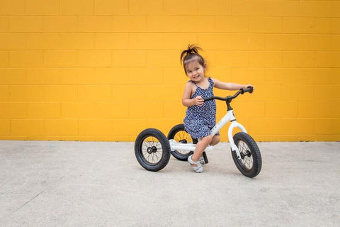 child on a white tricycle