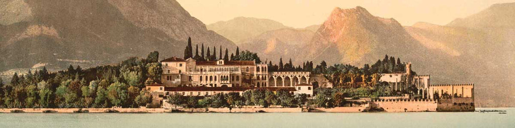 A photochrom picture of a fancy hotel behind scenic Lake Como, Italy