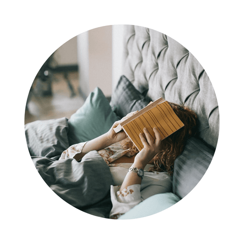 Femme qui lit un livre dans son lit