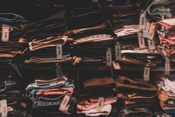 stacked jeans on a clothing rack