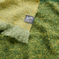 A close up image of a green and yellow alpaca throw.