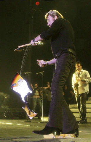 Johnny Hallyday qui casse une guitare sur scène lors du Flashback tour 2006/2007