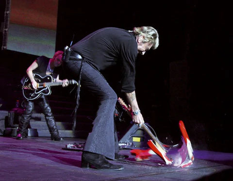 Johnny Hallyday qui casse une guitare sur scène lors du Flashback tour 2006/2007