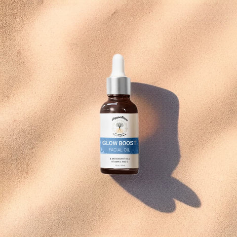 Glow Boost Facial Oil on sand