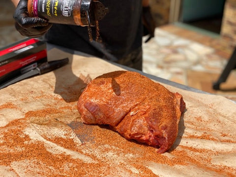 Rubbing pork shoulder with BBQ Rub