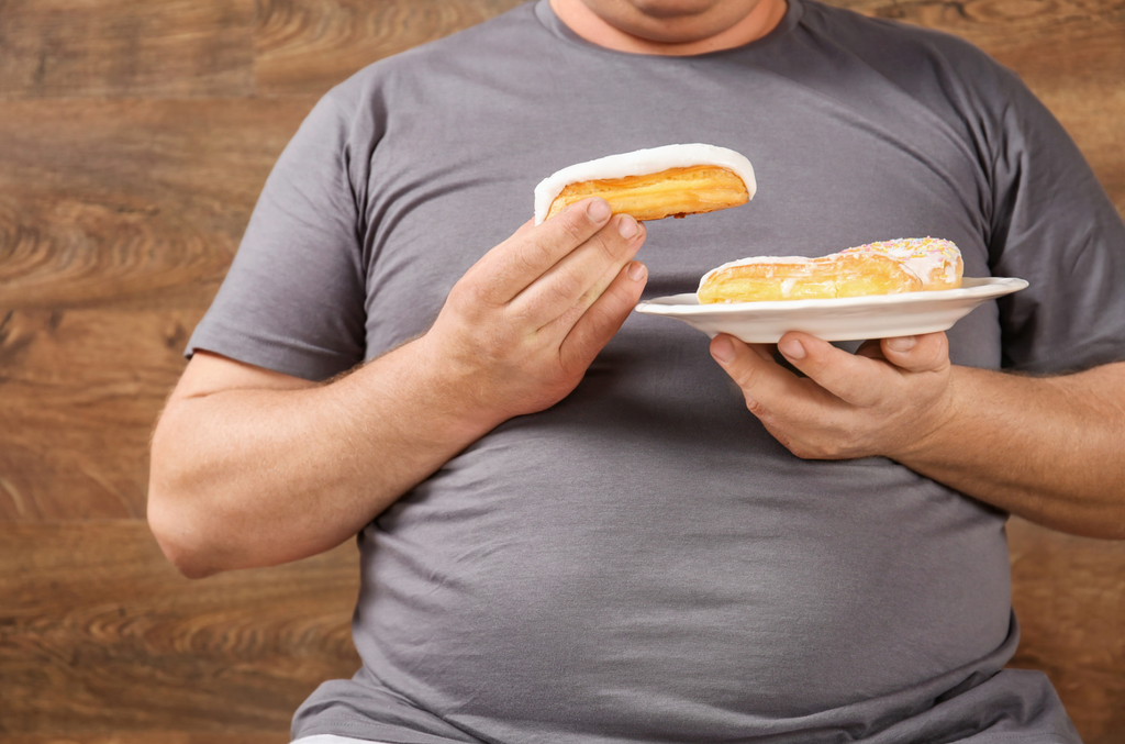 overweight person eating donuts