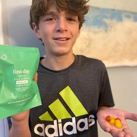 a teenage boy showing his palm with gummies on top