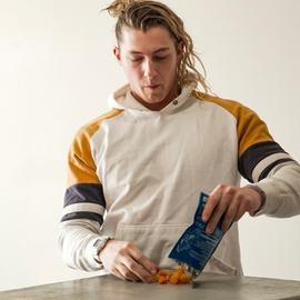 man with long hair pouring mens vitamins on the table