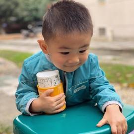 little boy holding tightly onto kids vitamins