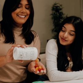 mom pouring vitamins for her teenage daughter