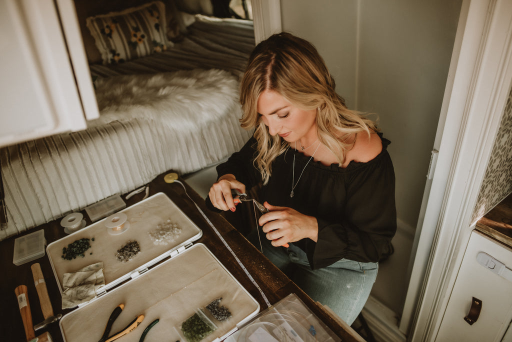 Julia, the owner of Topaz & Pearl, is making handcrafted bohemian jewelry from inside her campervan mobile studio