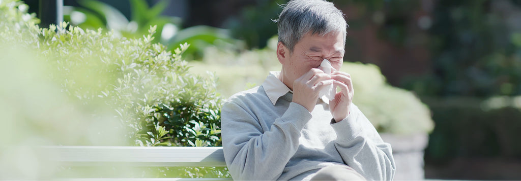 Man sneezing on bench