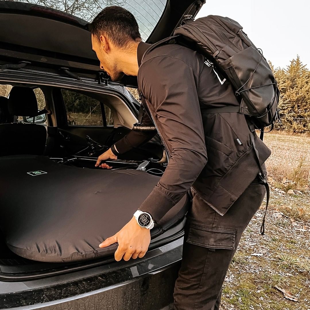 A man putting bicycle cover inside of his car