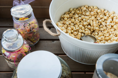 National Caramel Popcorn Day - April 6th - Popcorn and Candy on Table