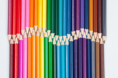 overhead view of colored pencils arranged to form a wave shape