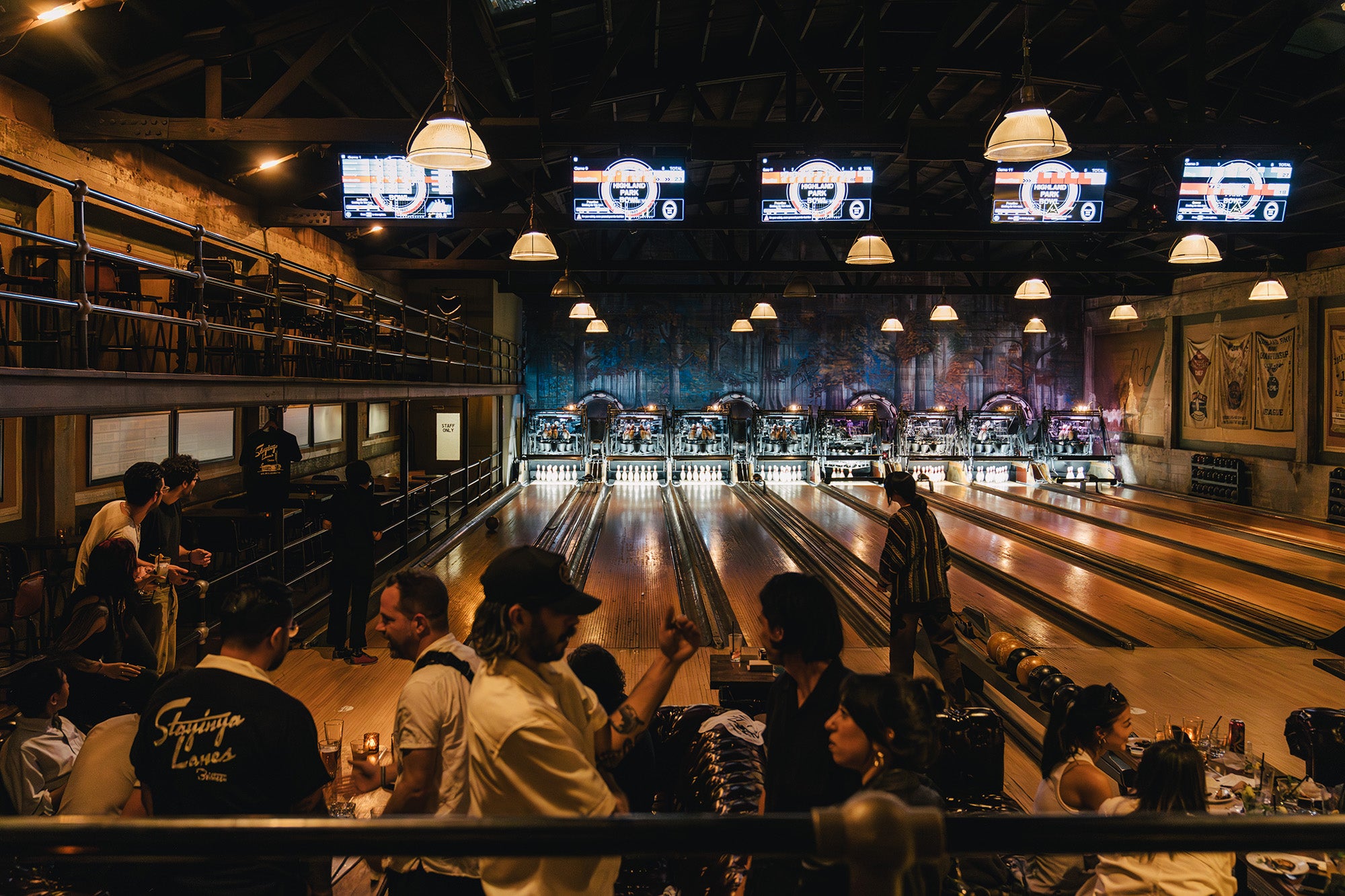 A wide view of a dark vintage bowling alley.