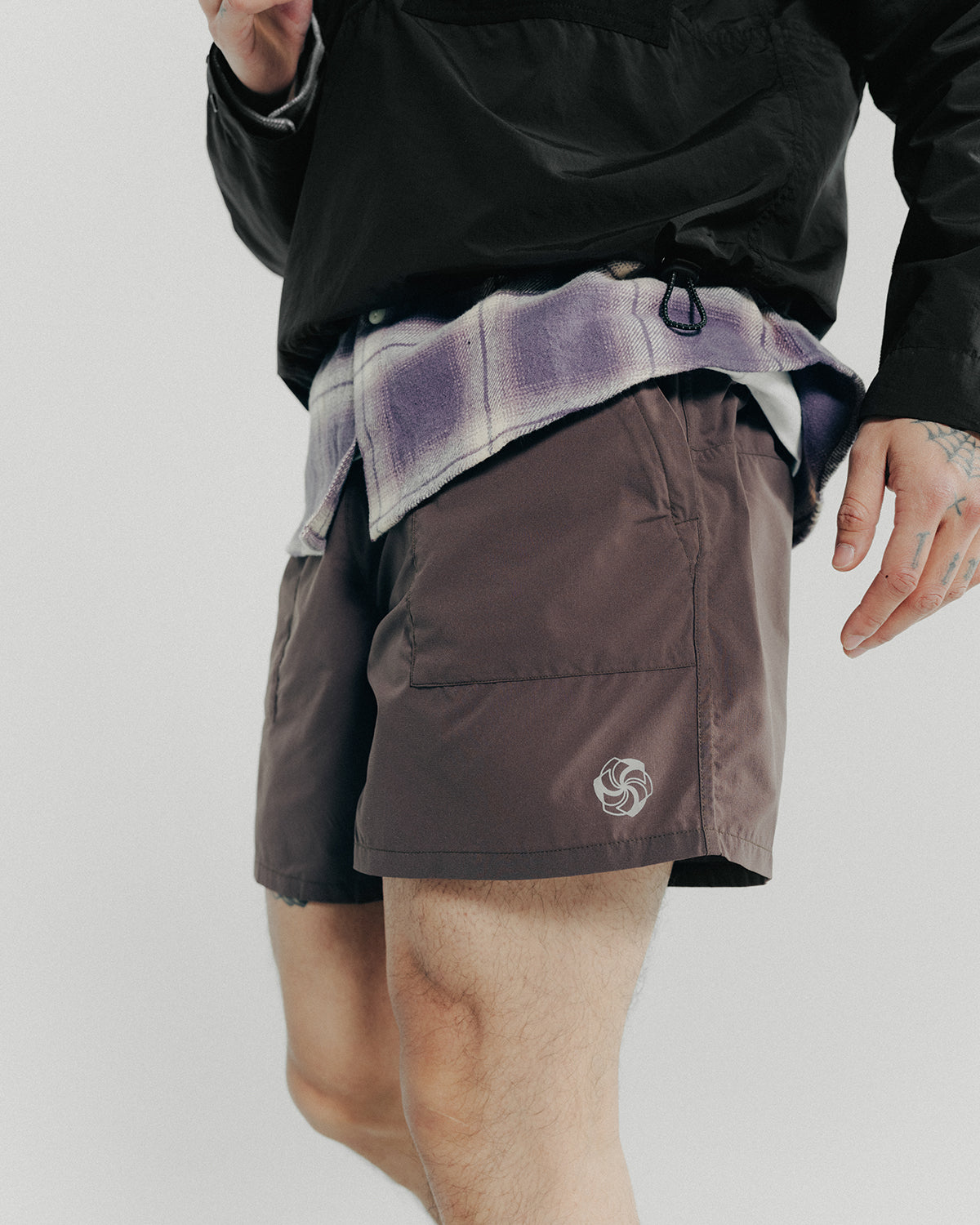 A detail shot of a purple shirt and brown shorts