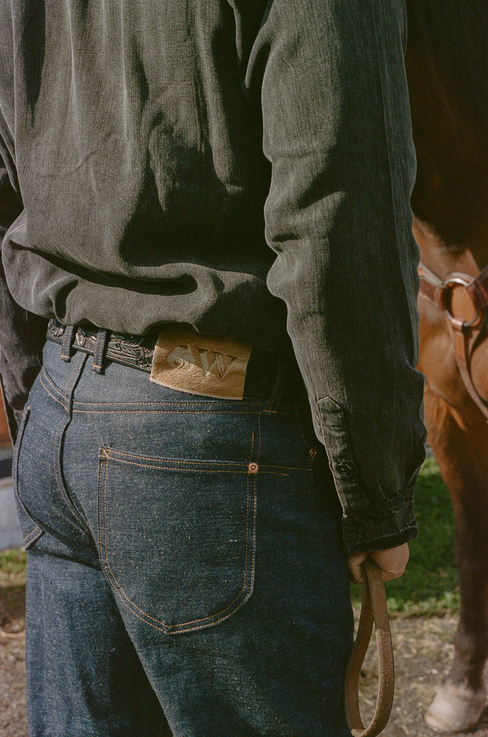 A shot of the back of a jeans that feature acorn back pockets and a hair-on-hide patch.