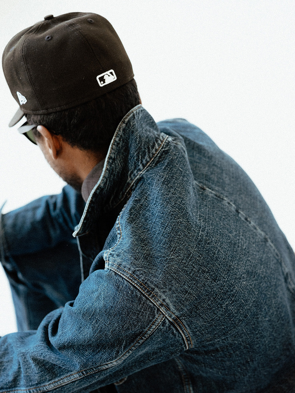 A detail shot of the back of a stonewashed denim jacket.