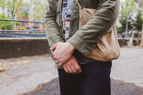 A detail shot of Chris crossing his arms in front of his body.