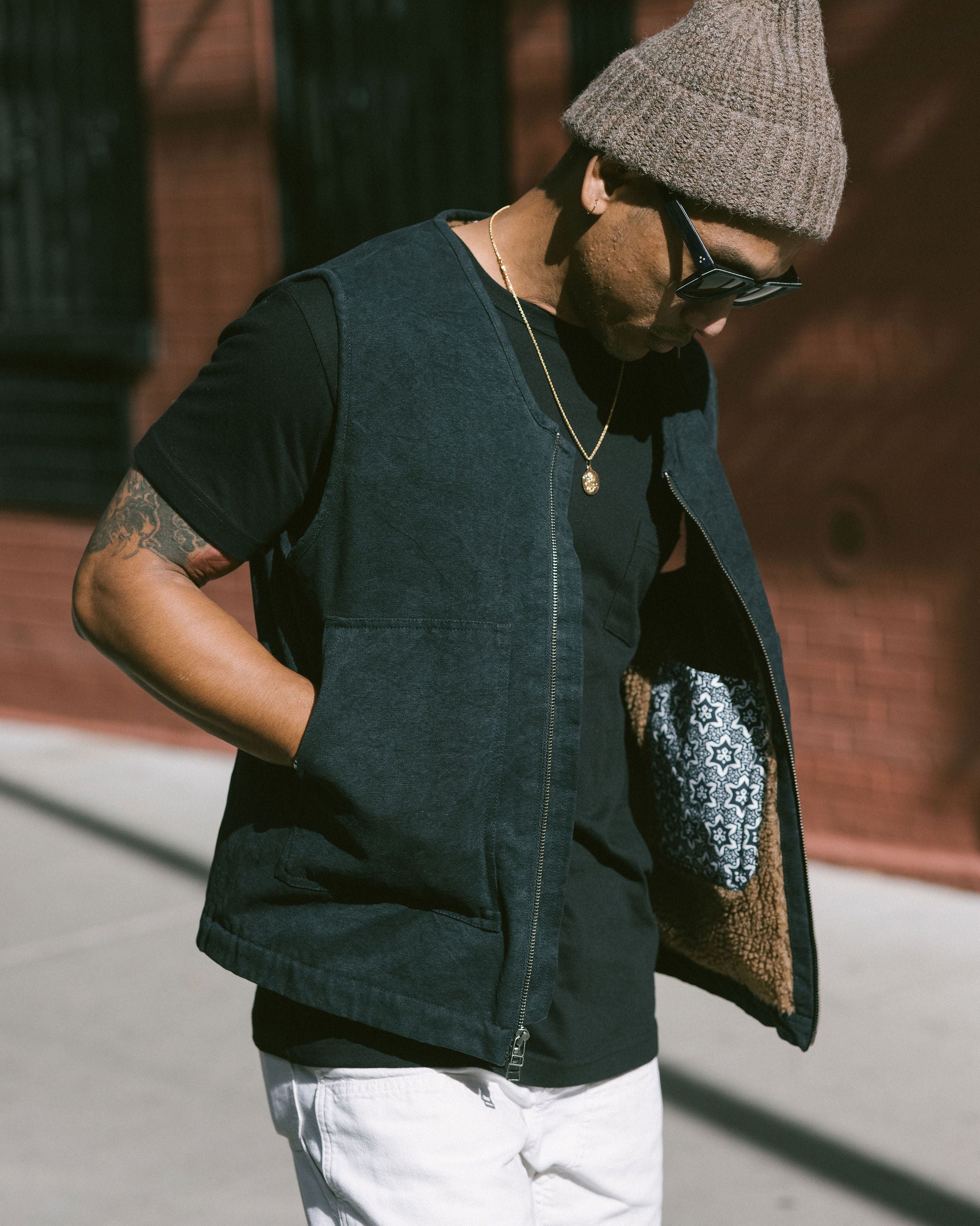 A man in a washed down black vest with a fleece lining.