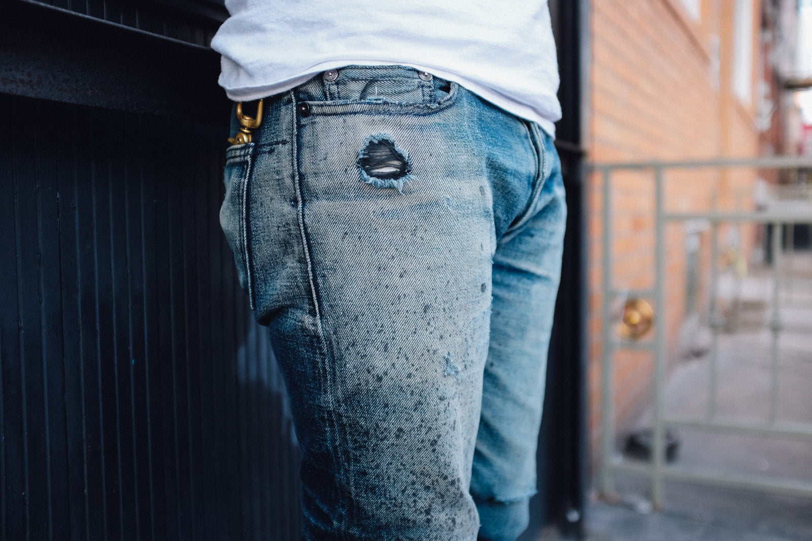 An up close photo of a splattered and faded pair of jeans.