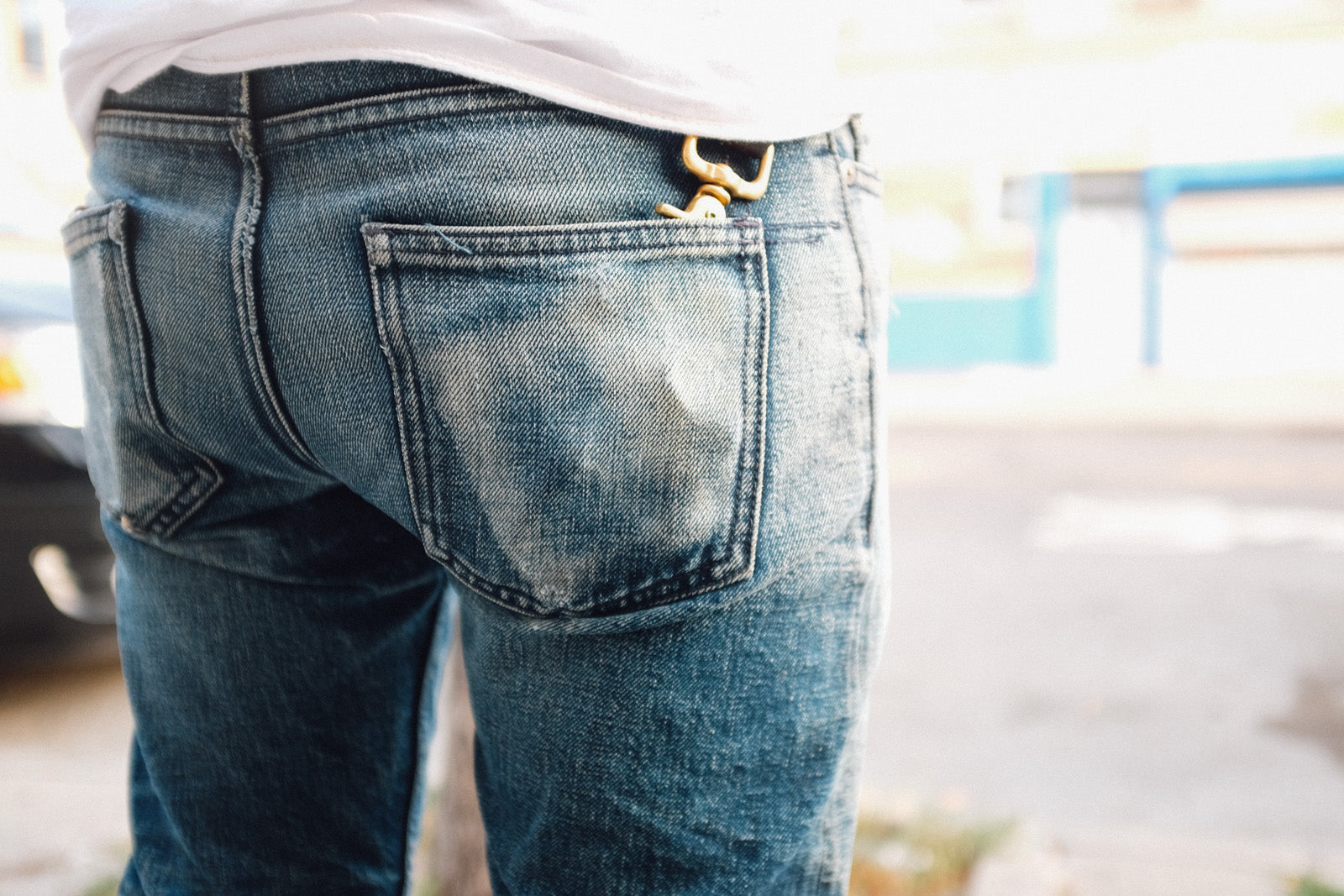 A photo of the backside of a faded pair of blue jeans.