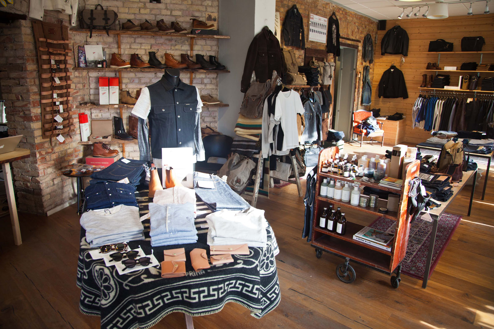 Interior shot of Meadow shop with tables and racks displaying clothing.