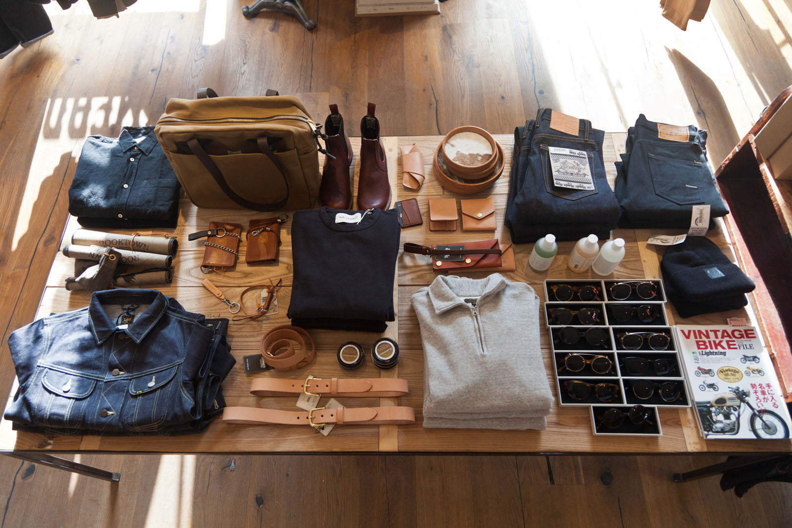 Overhead shot of a display table with various items on it, such as a denim jacket and rugby-style shirt