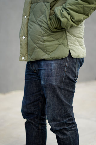 A detail shot of Roland's down jacket and the fading that is occurring on his 3sixteen jeans.