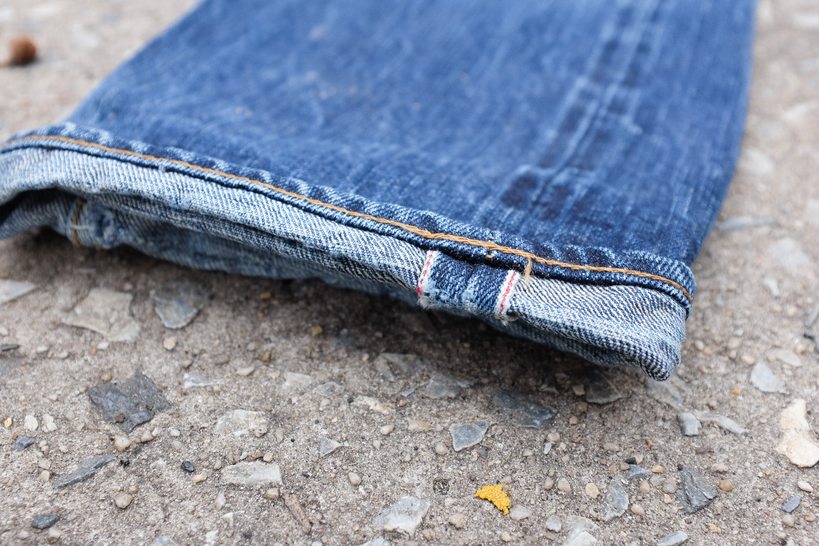 Detail shot of upturned denim cuff displaying slight fraying and selvedge ID.