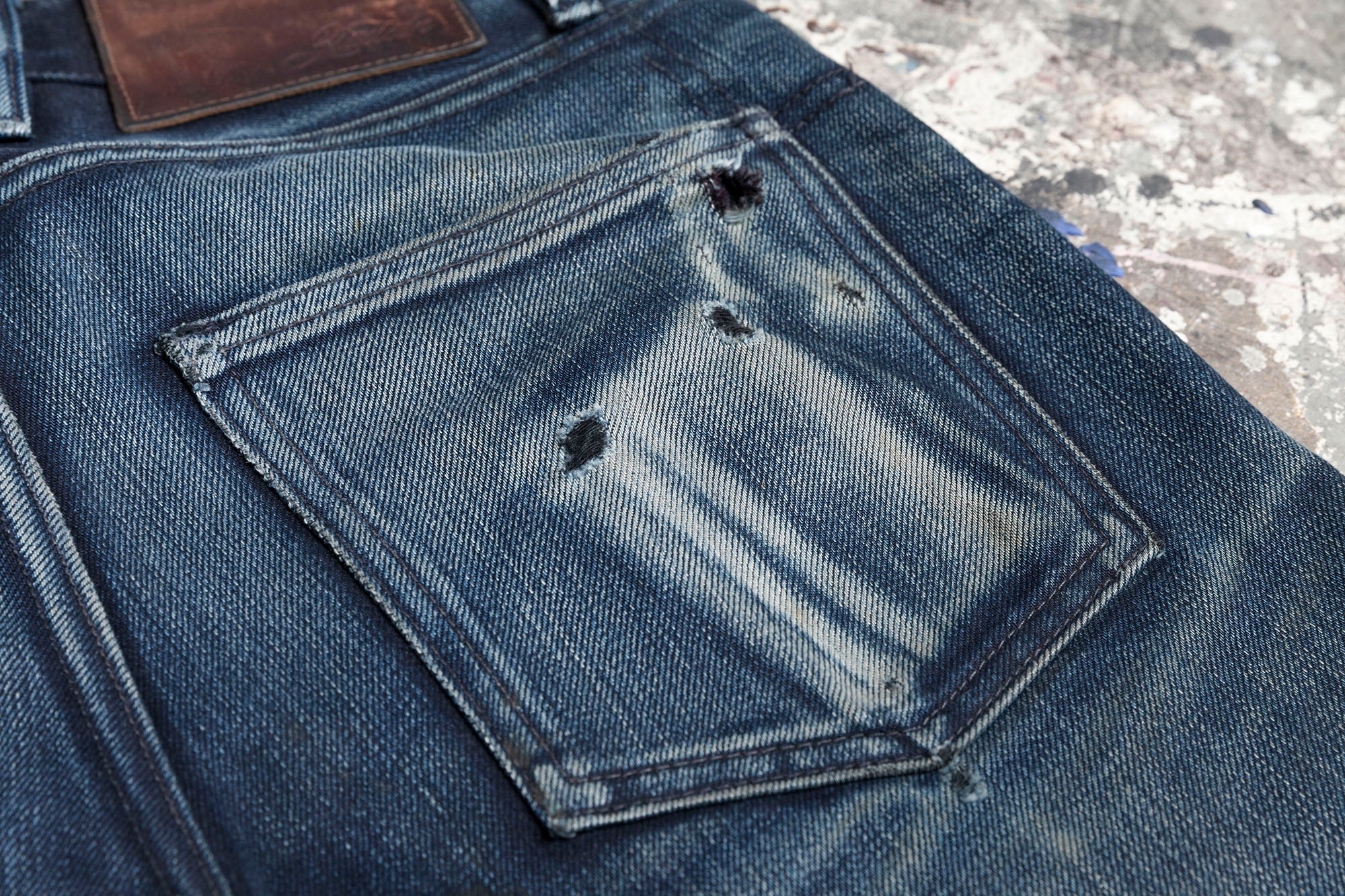 Closeup of the right rear pocket with fading and threadbare areas.