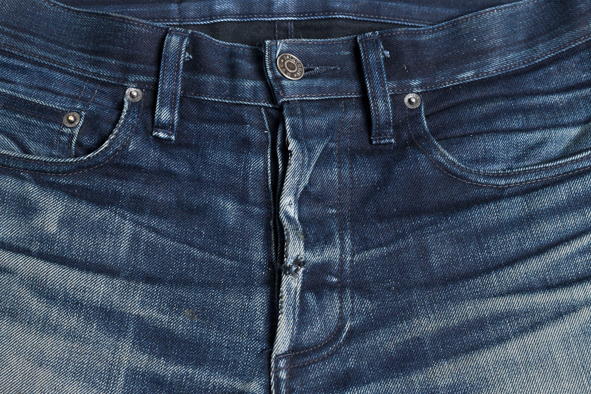 Closeup on fading of the button-fly on a pair of SL-120x denim.