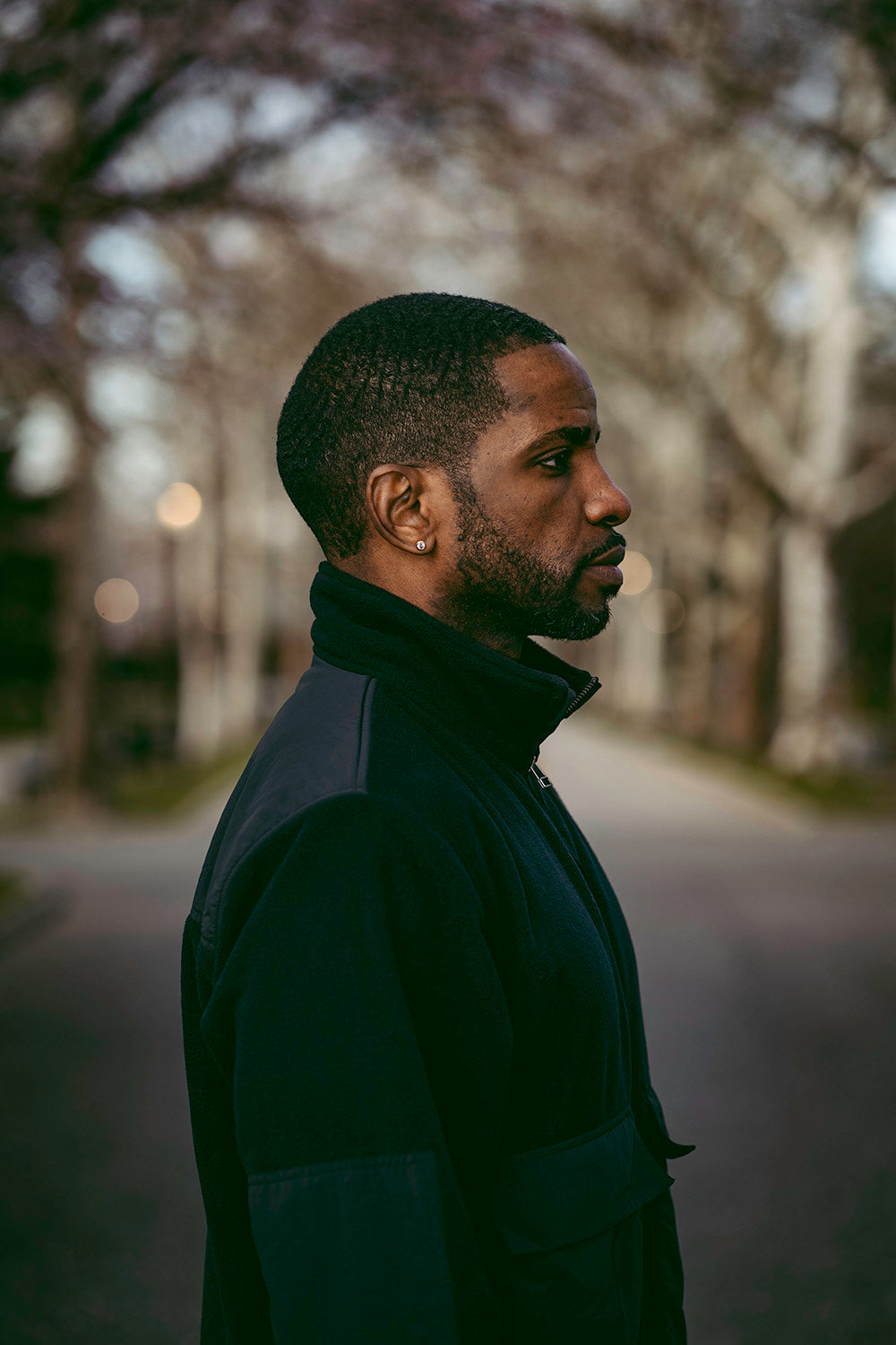 A side profile of a man in a black fleece jacket.