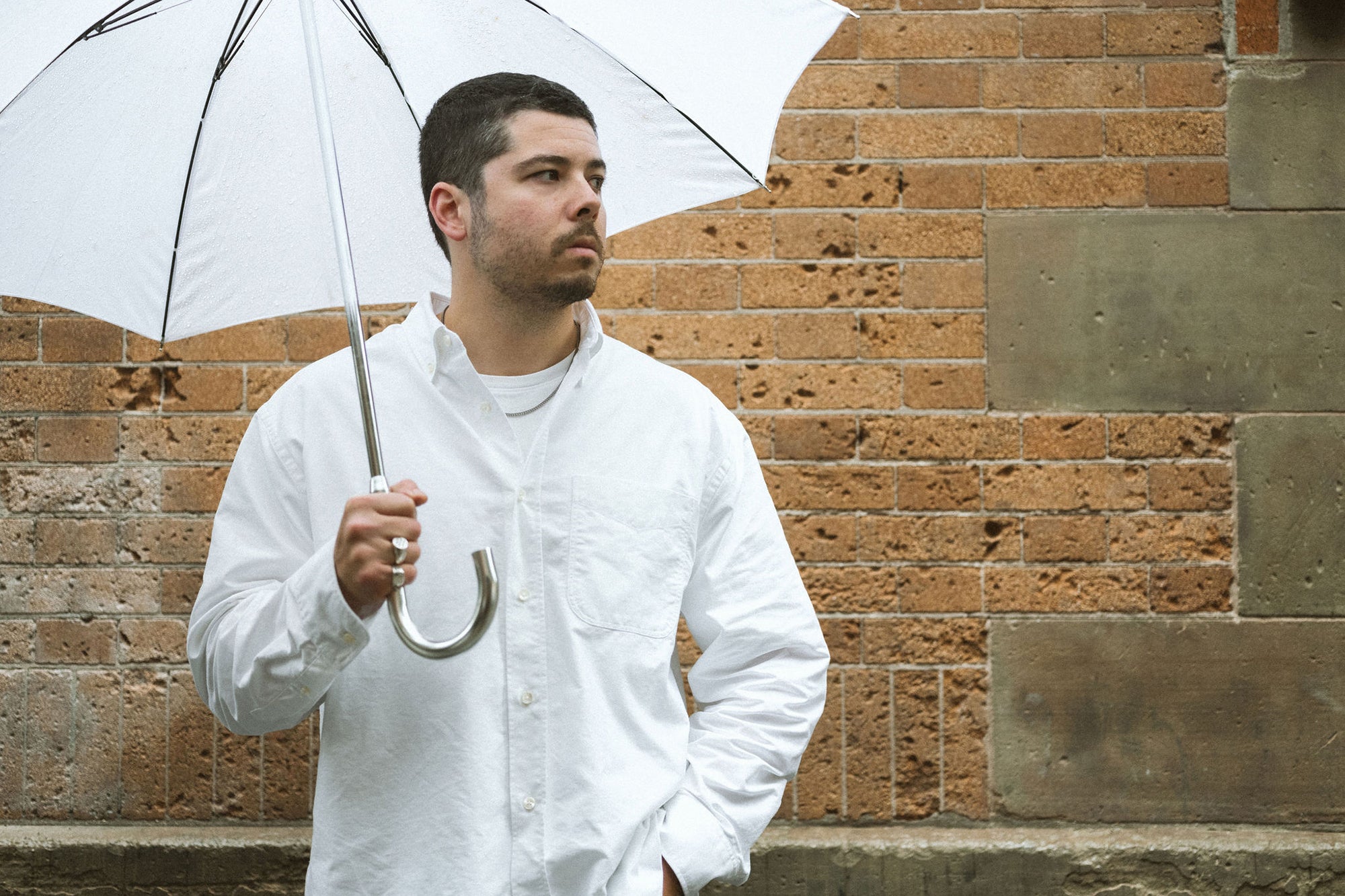 A man in a white shirt with a white umbrella.